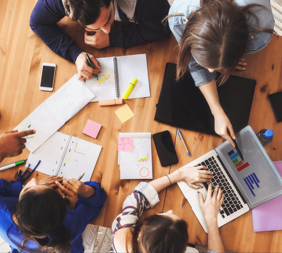 Overhead view of a team doing research and brainstorming ways to market to their target audience.